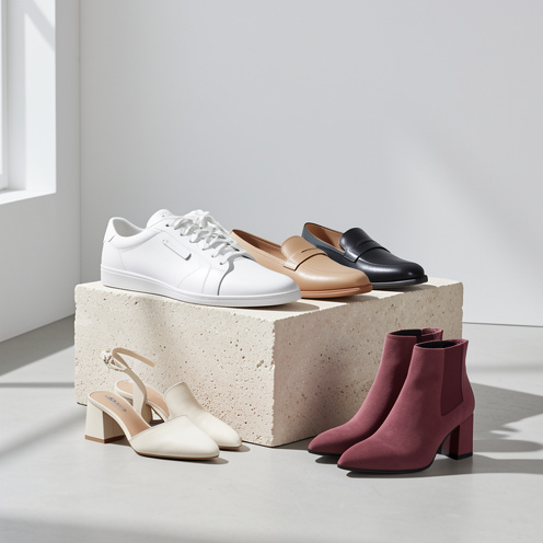 Collection de chaussures tendance pour femme, comprenant des baskets blanches, des mocassins, des sandales à petit talon et des bottines dans des tons neutres.